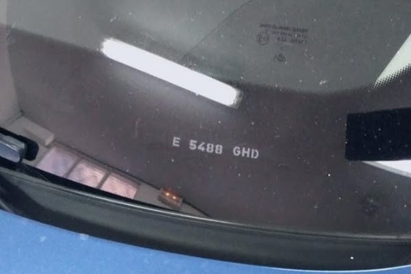 Matrícula grabada en la esquina de una luna